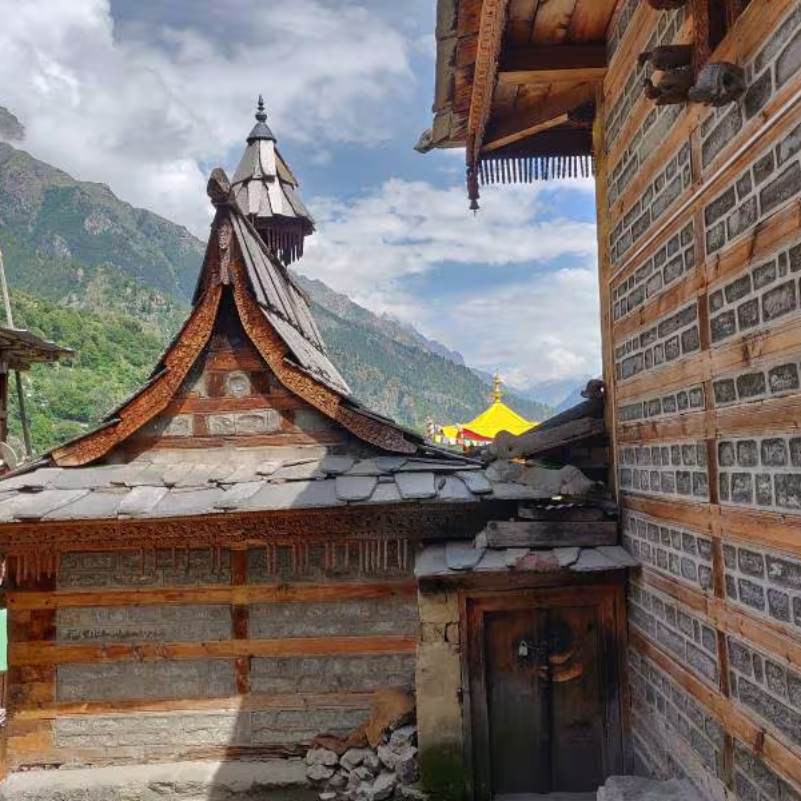 Carved wooden entrance and temple courtyard at Kamru Fort