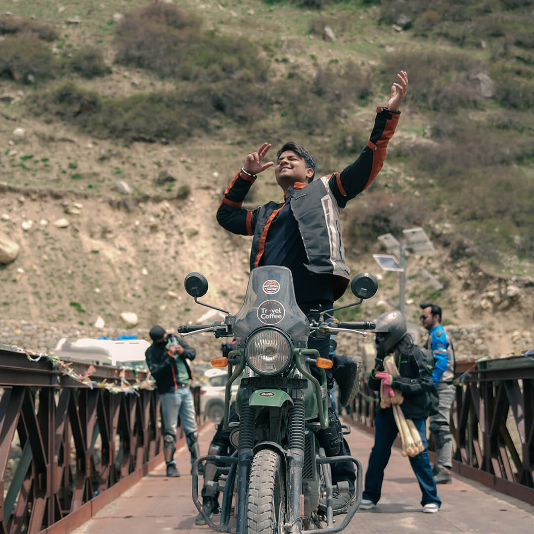Rider celebrating on bridge during a Spiti Valley bike trip.jpg.jpeg