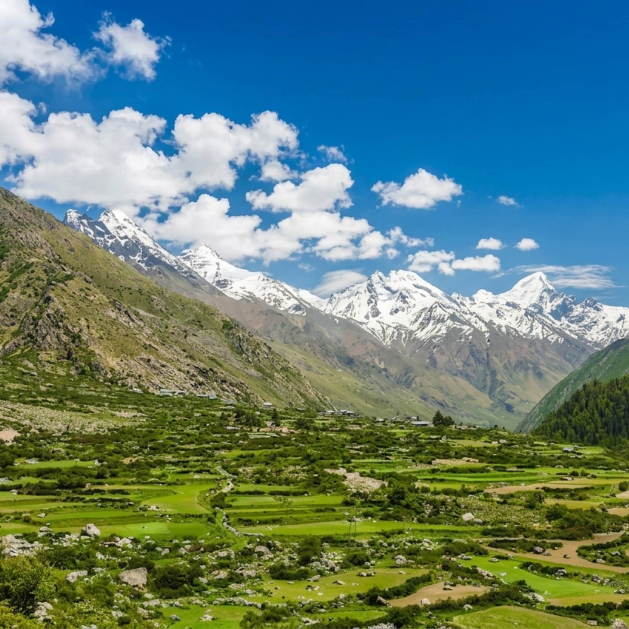 Traditional Kinnauri village in Sangla Valley surrounded by snow capped peaks