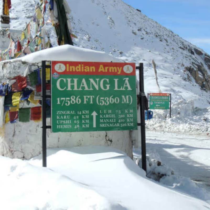 Chang La Pass under a clear blue Ladakh sky with barren peaks on both sides