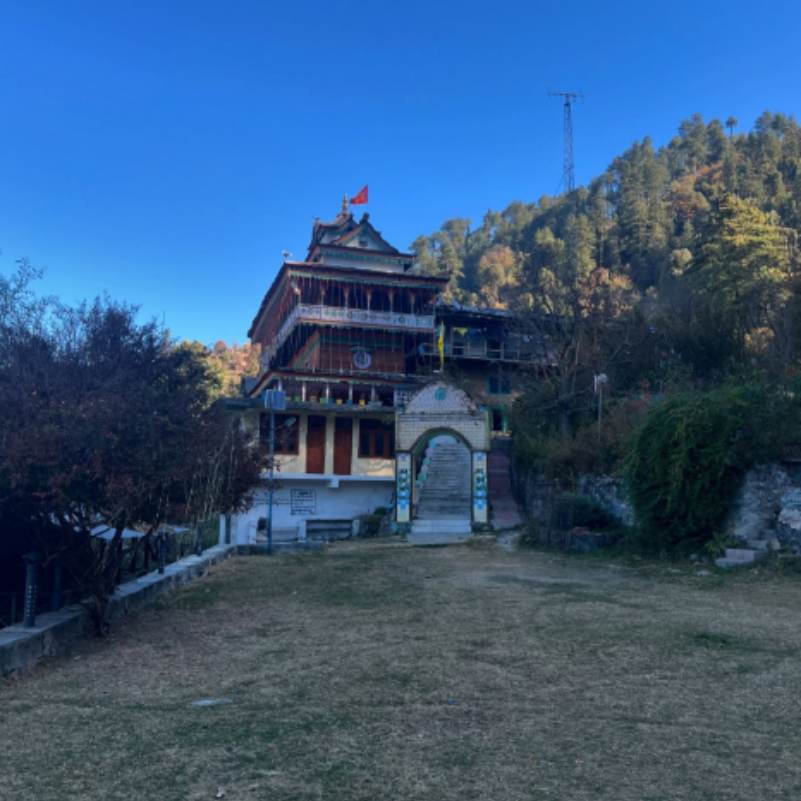 Front view of the Kath Kuni temple with carved wooden pillars and a slate roof