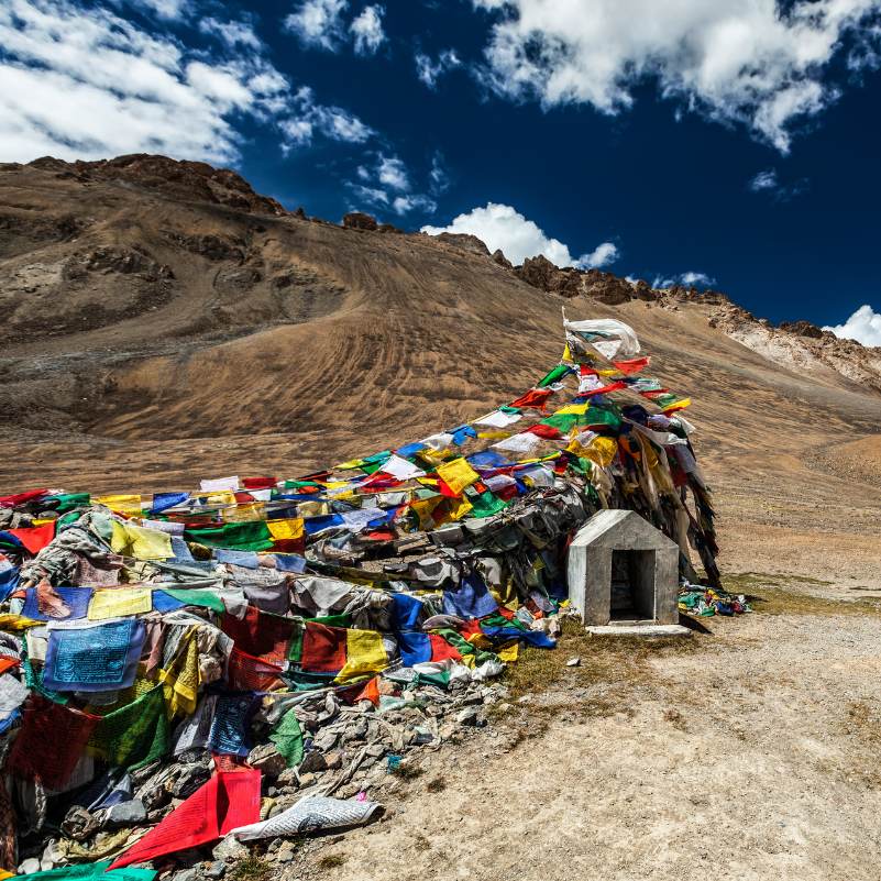 Panoramic view from the top of Khardung La with peaks of the Ladakh range and the descent road visible toward Nubra valley