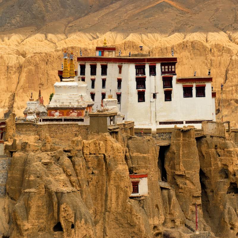Sunlit Lamayuru Monastery amid barren hills.jpg